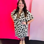 Leopard mini dress with dolman sleeves, pockets,and taupe and black v-neckline.
