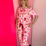 Bow-print pajama set with pink stripes, red waist tie, and ruffled pants in soft, stretchy fabric.