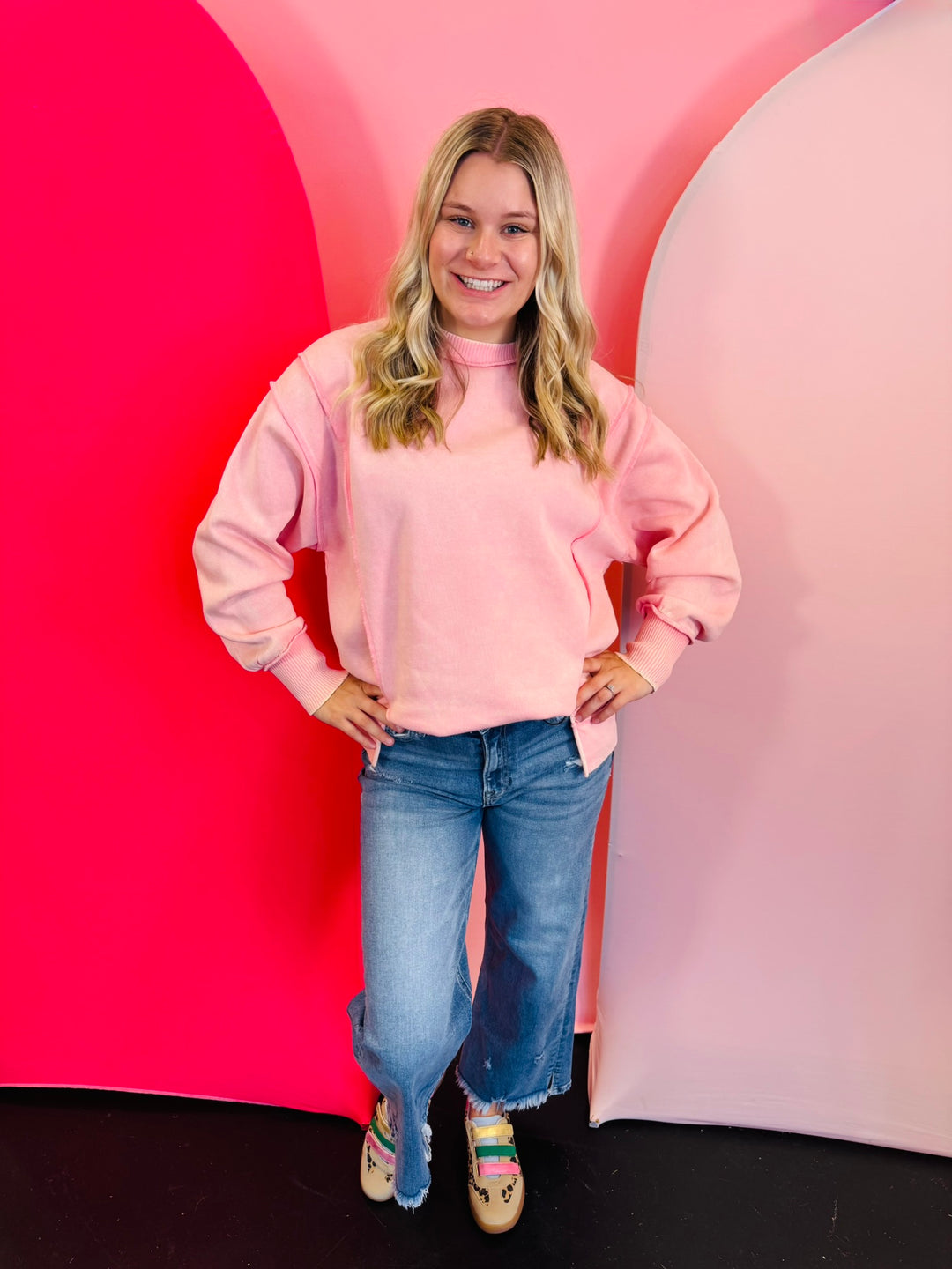 pink acid wash fleece sweatshirt with exposed seams, side slits, and a bottom band.