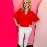 Ruby red collared V-neck airflow top with short sleeves and a lightweight, flowy drape.