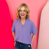 Lavender collared V-neck airflow top with short sleeves and a soft, lightweight drape.
