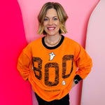 Orange sweatshirt with black neckline, cuff, and hem and  'BOO' and ghost design