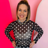 Sheer polka dot mesh top with mock neckline and lettuce hems for trendy layered styling.