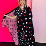 Black polka dot blanket with white, red, and pink dots on cozy fabric