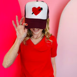 Mavis heart and arrow yarn embroidered maroon and white mesh trucker cap.