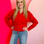 Ruby red ribbed collared zip-up sweater with two-way zipper and soft textured knit.