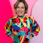 Coral floral print top with smocked neckline, puff sleeves, and lightweight non-sheer fabric.