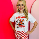 Santa rodeo graphic tee with “North Pole Rodeo” text on soft red cotton.