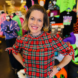 Red, green, and black plaid top with leopard accents, ruffled sleeves, and mock neckline.