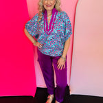 Teal leopard print top with magenta print, orchid contrast neckline, V-neck stand collar, and short sleeves