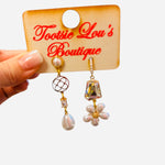 Asymmetrical gold earrings with pearl drops, iridescent stones, and floral pearl cluster design