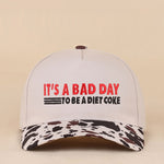 Two-tone snapback hat with It's A Bad Day To Be A Diet Coke embroidered saying.