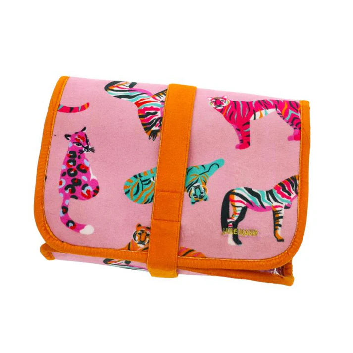 hanging toiletry bag with multiple zippered compartments made of pink velvet animal print pattern and with orange snap 