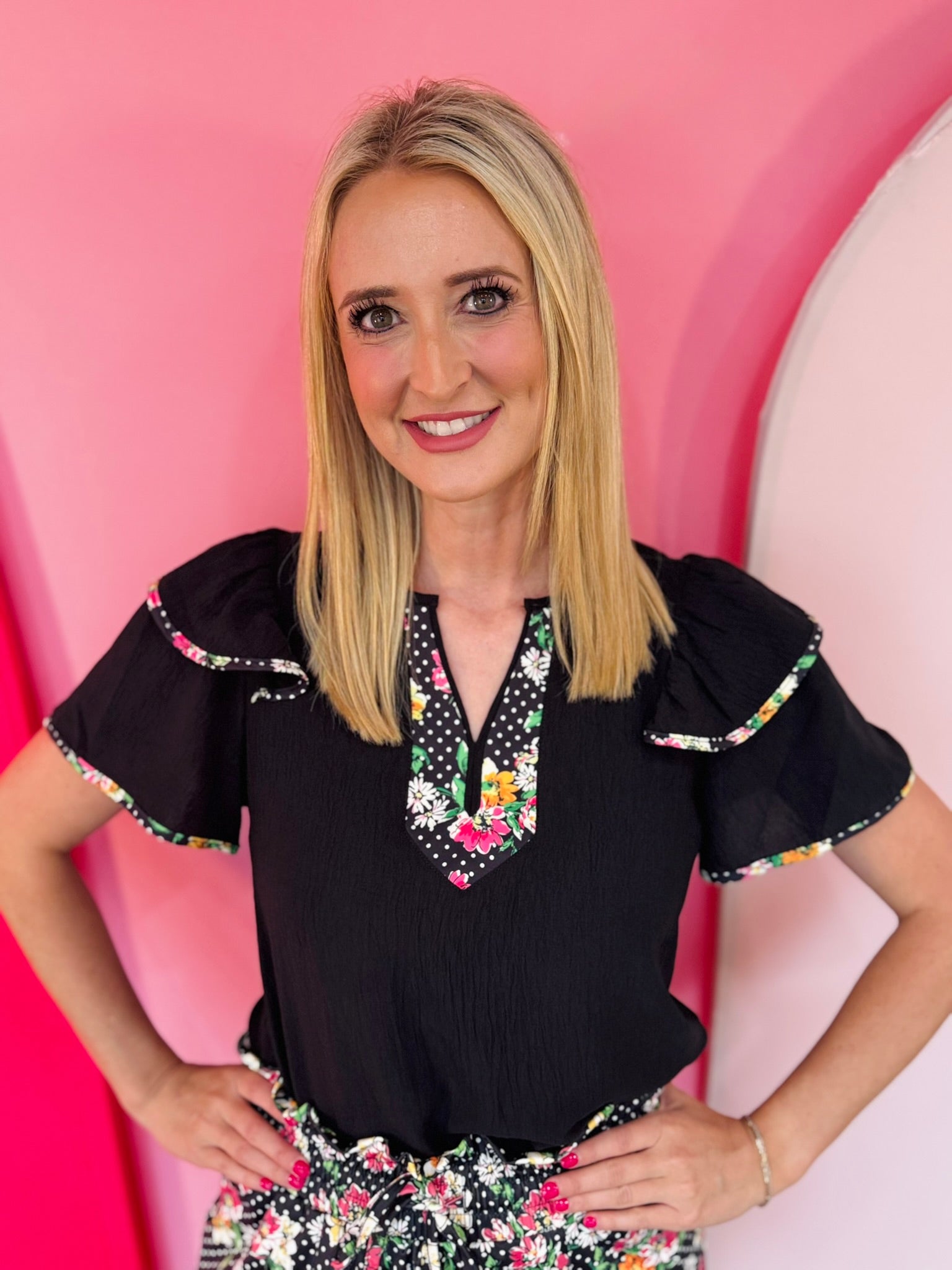 Daisy and polka dot blouse with flutter sleeves and feminine silhouette.
