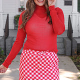 Red diagonal gingham skort with drawstring waist, side pockets, and built-in shorts for comfort.
