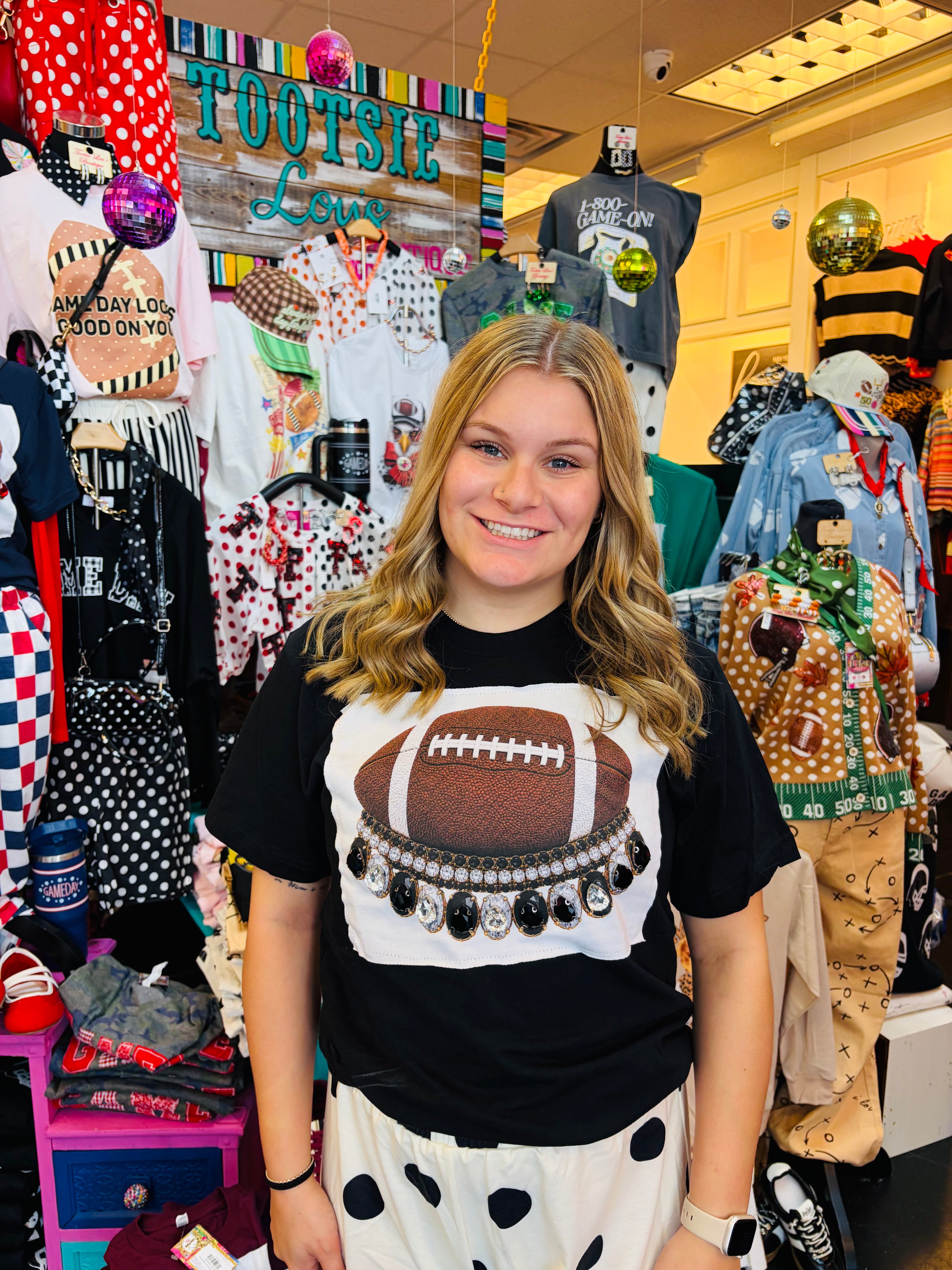 ootball tee with oversized black and clear rhinestone crystals and football graphic details.