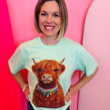 Mint tee with Highland cow graphic featuring oversized hand-set rhinestone jeweled collar accents.