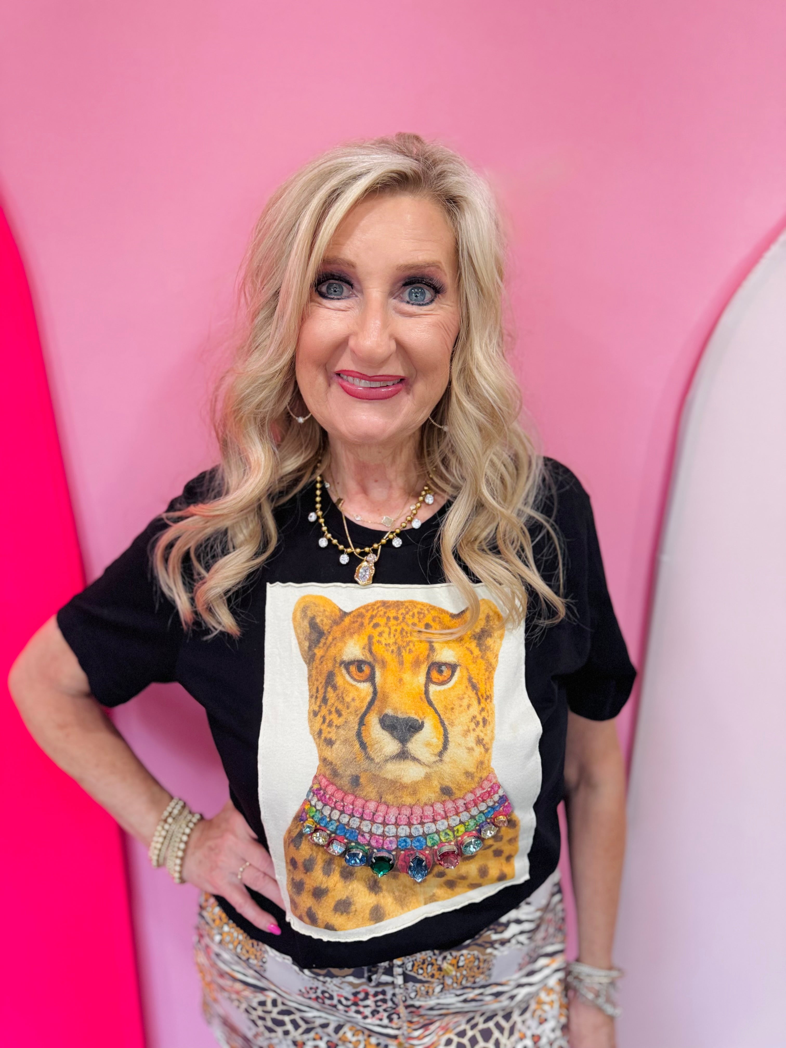 Black tee with white leopard patch and multicolored crystal necklace.