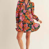 Jodifl vibrant floral tiered mini dress with V-neckline and striped cuffs on a dark background.