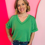 Kelly green corded rib knit top with relaxed fit and hi-low V-neck.
