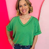 Kelly green corded rib knit top with relaxed fit and hi-low V-neck.