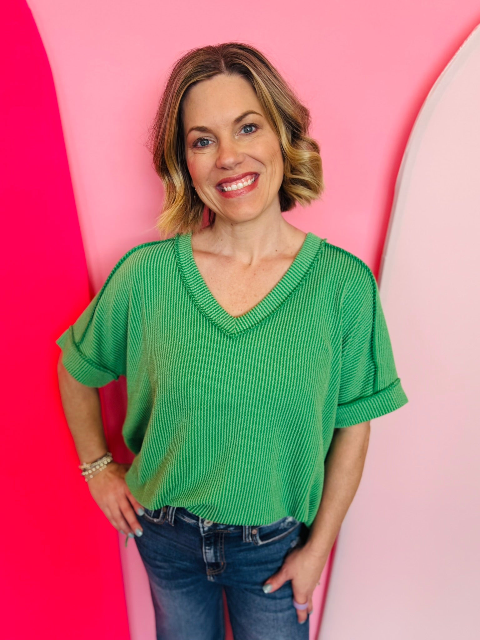 Kelly green corded rib knit top with relaxed fit and hi-low V-neck.