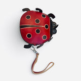 Red ladybug coin purse with black spots, zipper closure, and detachable wristlet strap.