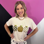 Graphic tee with three apples in leopard, checkered, and polka dot prints.