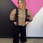 Leopard print top with black panels, scallop trim, and three-quarter puff sleeves