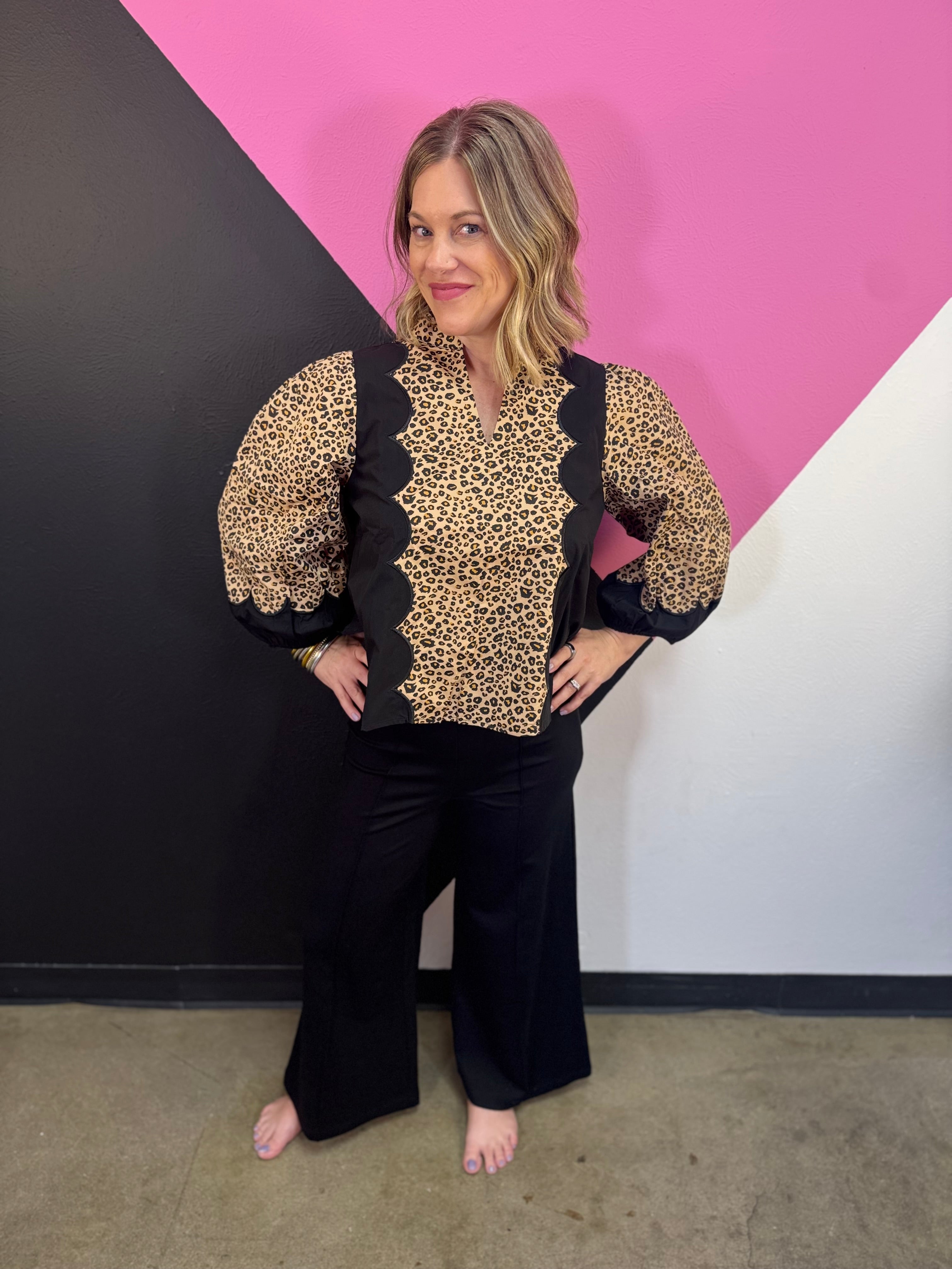 Leopard print top with black panels, scallop trim, and three-quarter puff sleeves