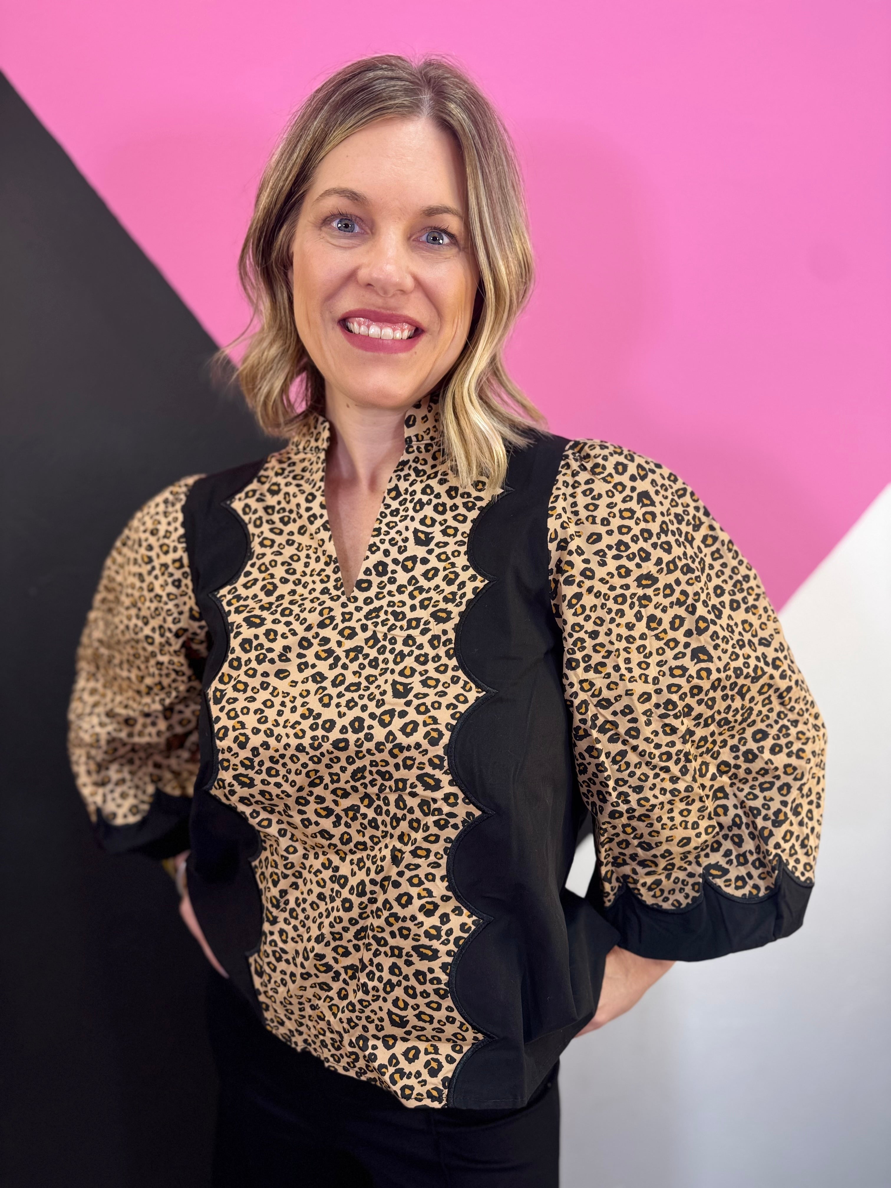 Leopard print top with black panels, scallop trim, and three-quarter puff sleeves