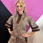 Leopard print pullover with rich brown contrast trim, zip neckline, and short wide sleeves.