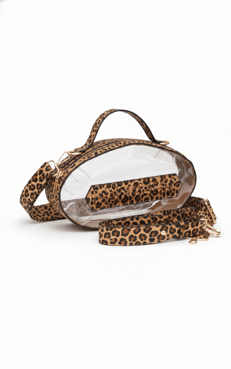 Leopard print football-shaped crossbody bag with gold hardware, top handle, and adjustable strap.
