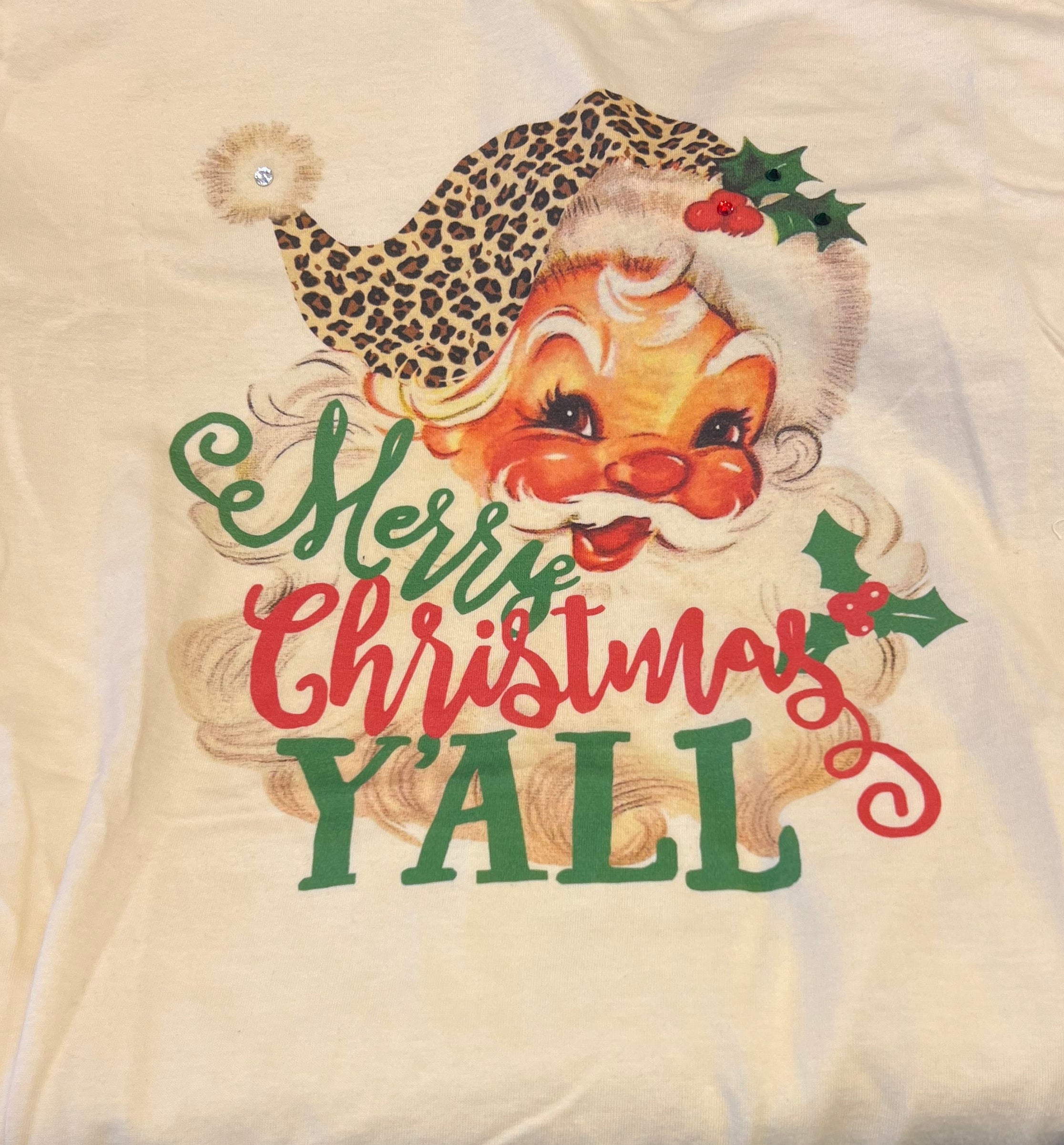 Cream rhinestone Christmas tee with vintage Santa, leopard hat, and “Merry Christmas Y’all” design.