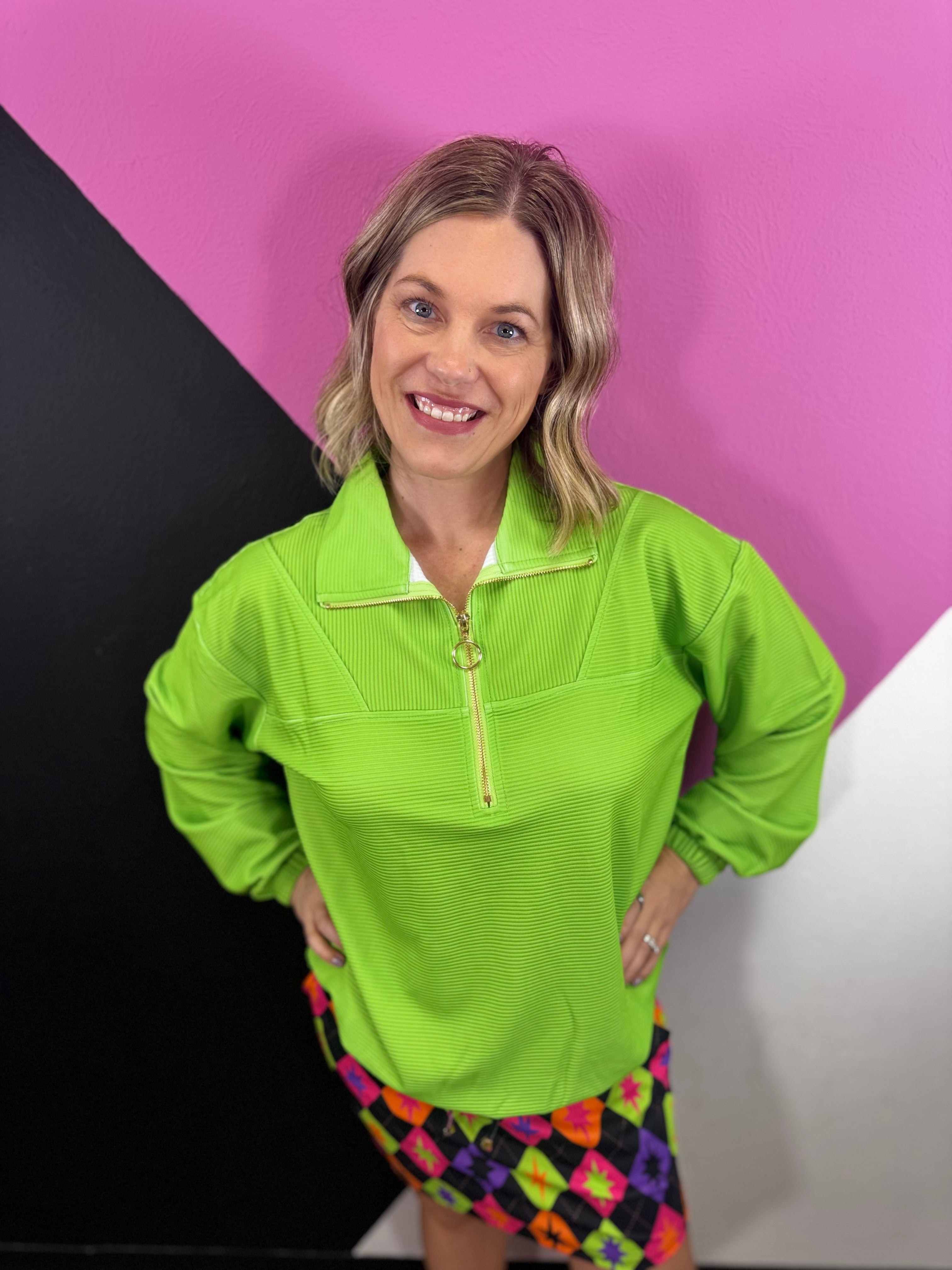 Neon green ribbed quarter zip pullover with collared neckline and gold-tone zipper.