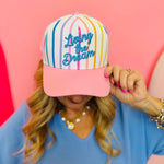 Colorful striped baseball hat with pink brim and Living the Dream embroidery.