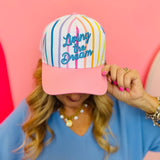 Colorful striped baseball hat with pink brim and Living the Dream embroidery.