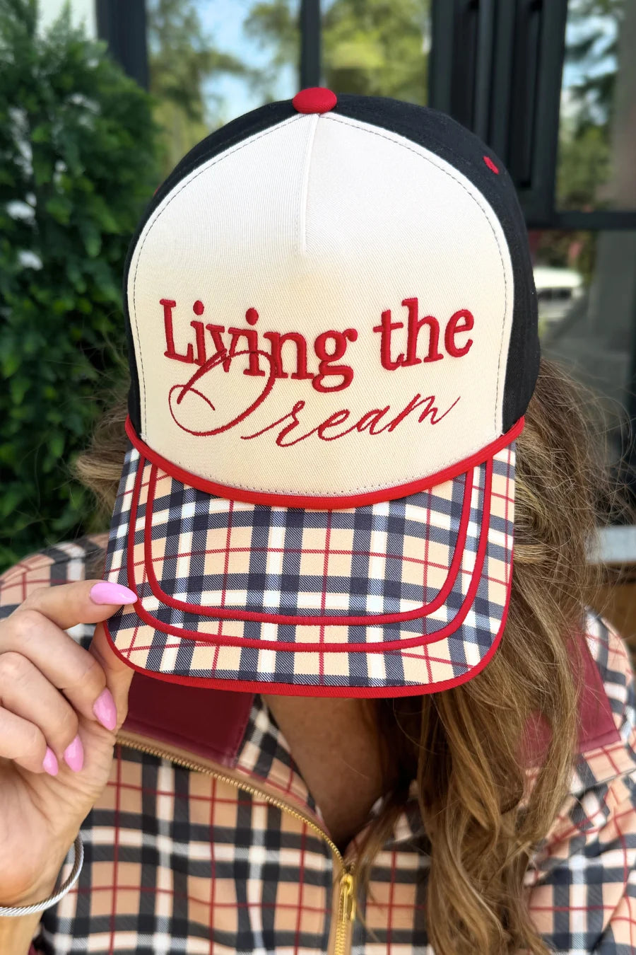 Cream and black Living The Dream hat with red embroidery and plaid printed bill.