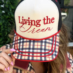 Cream and black Living The Dream hat with red embroidery and plaid printed bill.