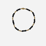 Gold and coal crystal beaded bracelet with mixed patterned stretch design.