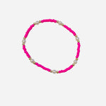 Gold filled bracelet with pink beads, pearl accents, and stretch fit.