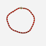 Gold filled bracelet with red beads, pearl accents, and stretch fit.