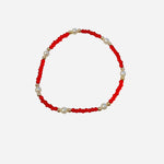 Gold filled bracelet with red beads, pearl accents, and stretch fit.