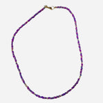 Gold filled necklace with purple beads and gold accent details.
