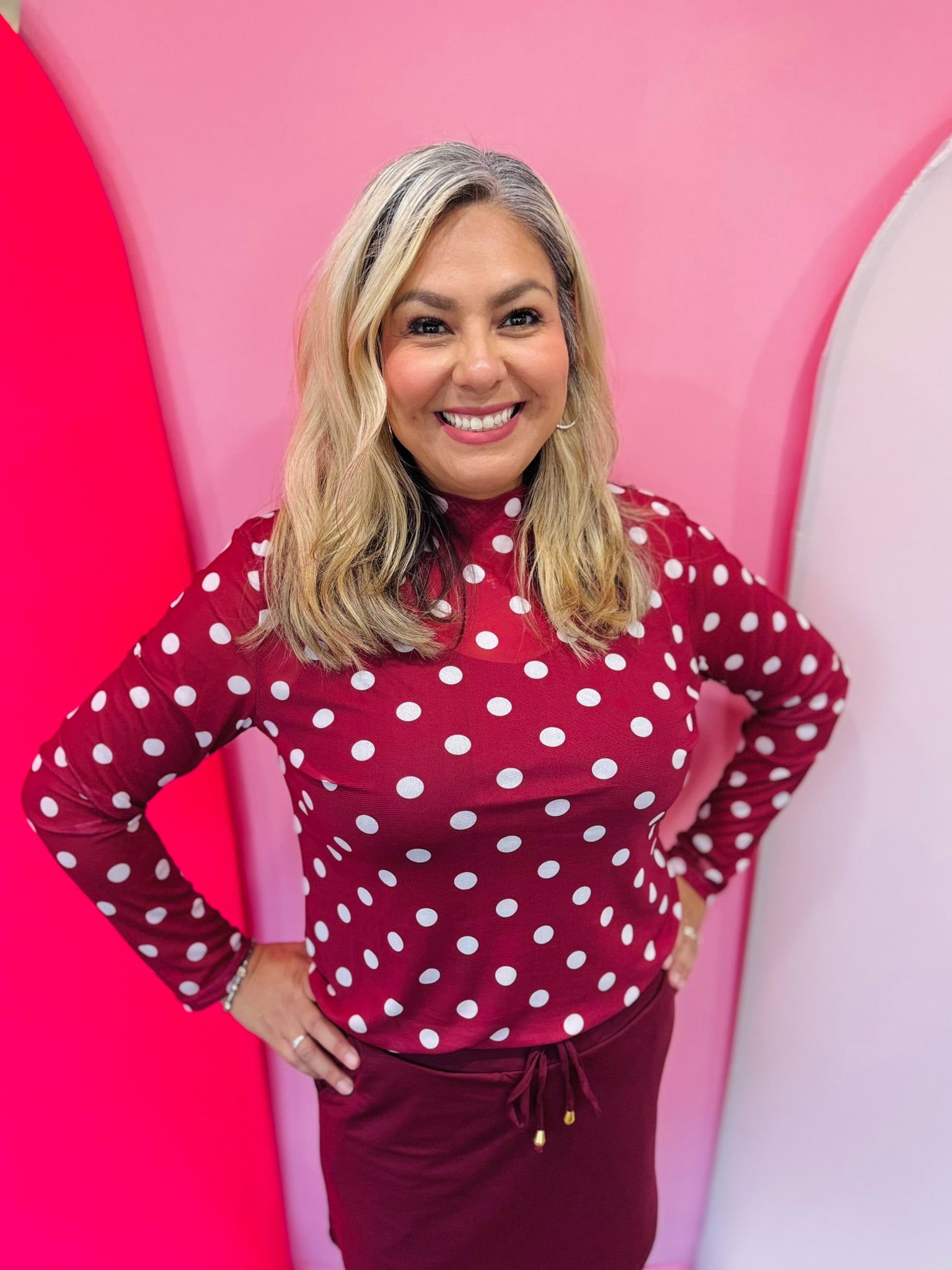 Maroon mesh top with white polka dots and mock neckline.