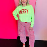 Lime green long sleeve tee with bold red sequin “MERRY” lettering across the front, festive holiday style.