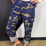 Green and black camo crop jeans with high-rise waist, straight leg, and wide rolled cuffs.