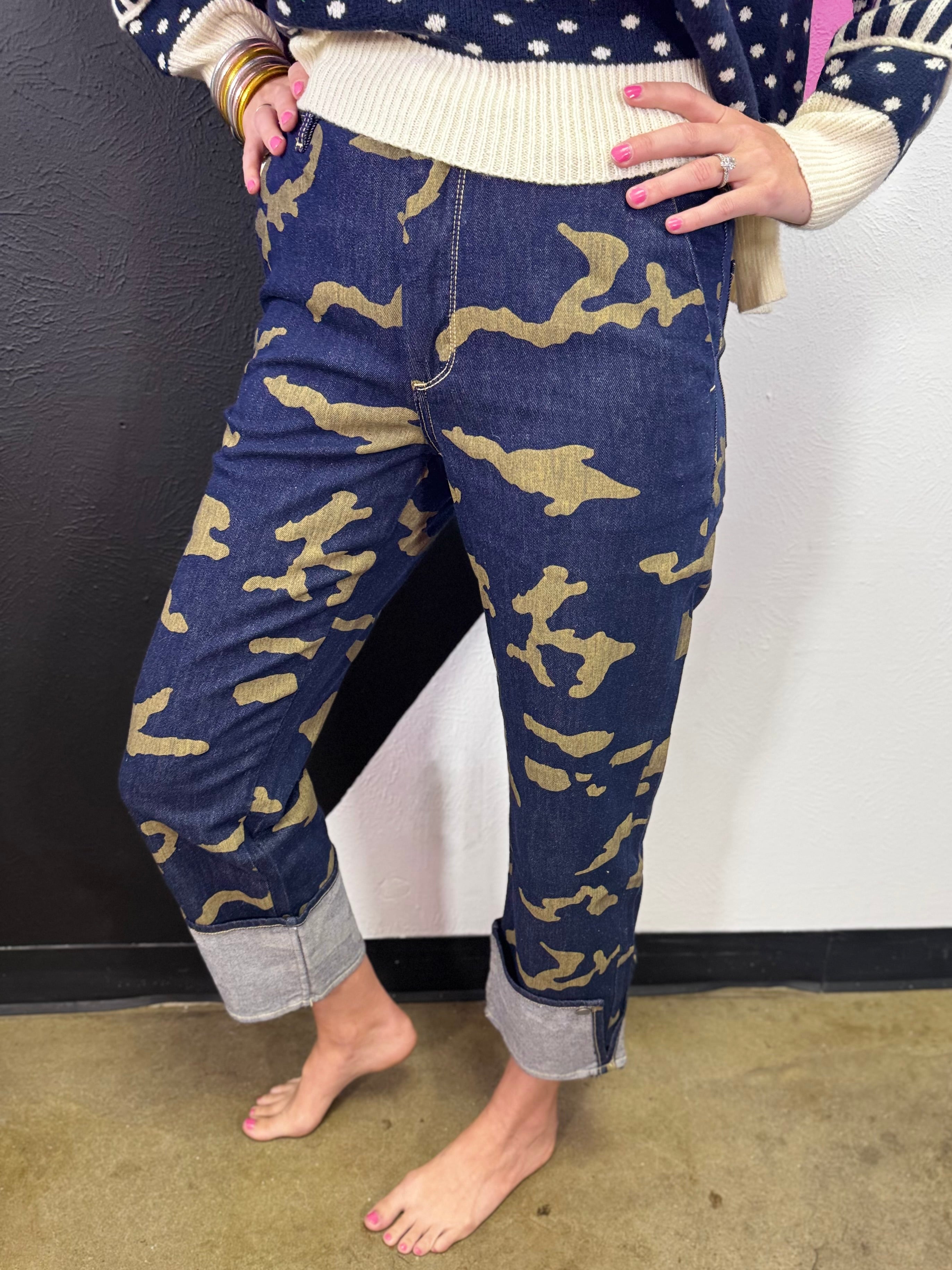 Green and black camo crop jeans with high-rise waist, straight leg, and wide rolled cuffs.