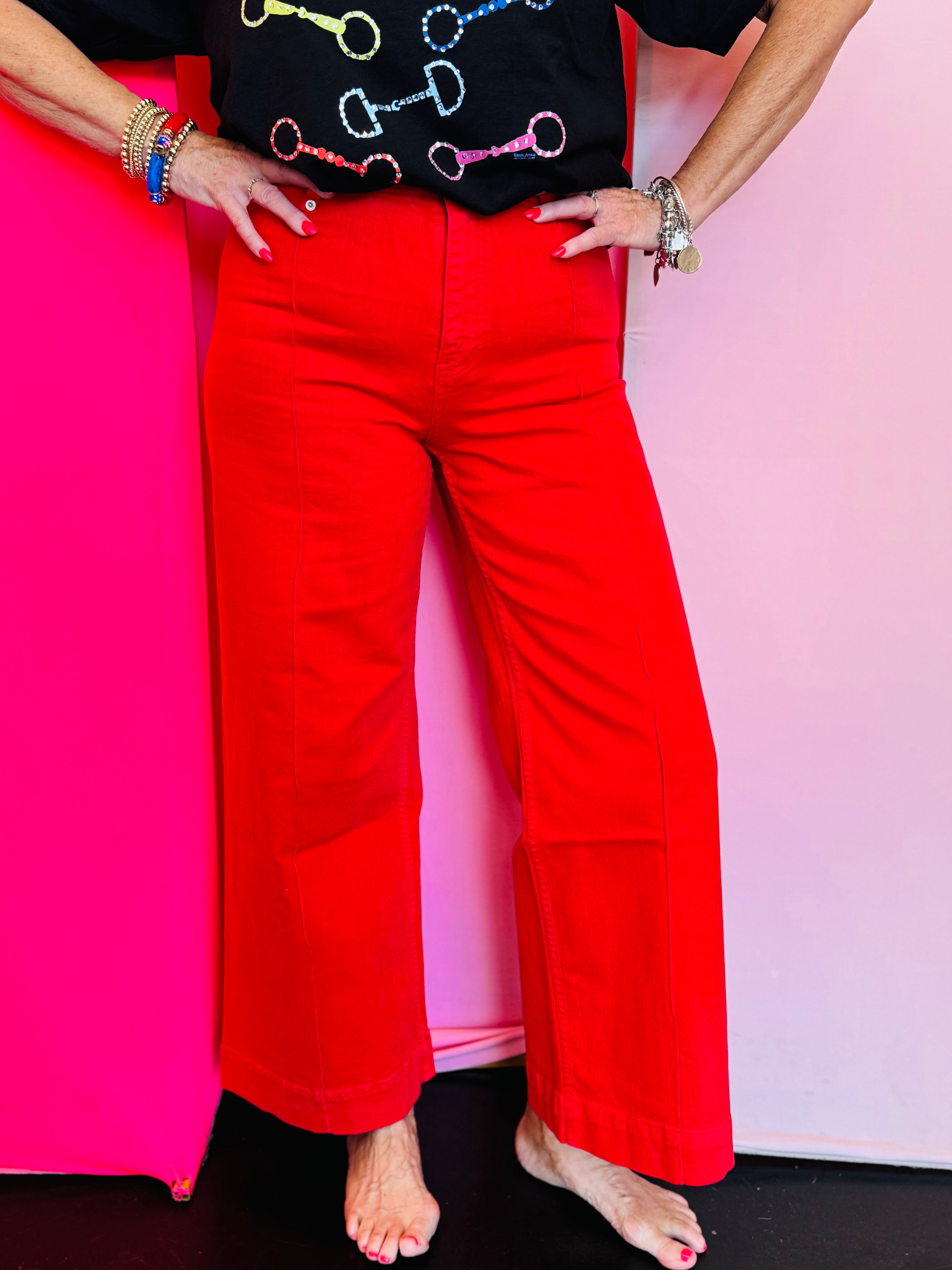 Red high-rise wide leg ankle jeans with structured waistband and flowy fit.