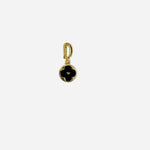 Gold tone huggie clip charm with round pendant featuring black quatrefoil centerpiece
